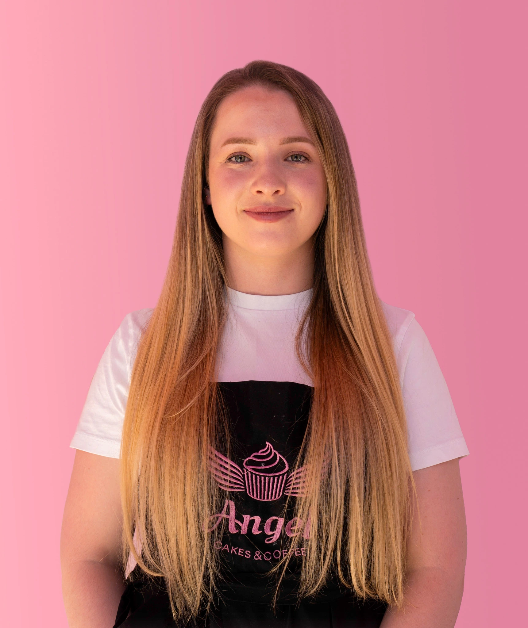 Medgrundare av Angel Cakes & Coffee framför caféets logotypvägg