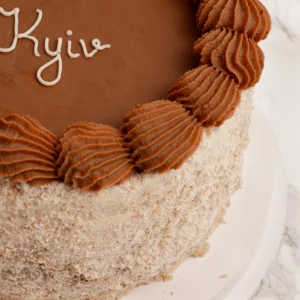 Kyivtårta - Angel Cakes & Coffee Närbild på Kyivtårta med chokladglasyr, spritsat chokladsmör och nötkaksmuletäcke