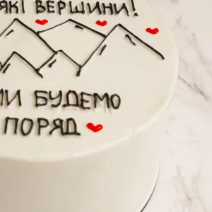 Närbild på Mountain tårtas handritade bergsmotiv och ukrainsk text med röda hjärtan