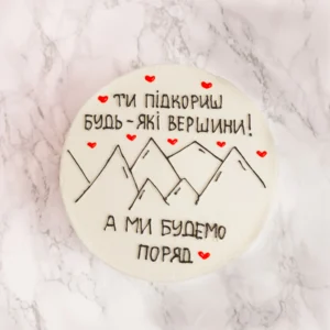 Mountain tårta fotograferad rakt ovanifrån med bergsmotiv och ukrainsk text med röda hjärtan