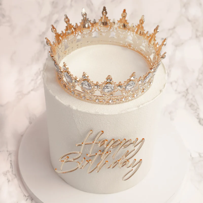Princess tårta fotograferad snett ovanifrån med detaljrik guldkrona och Happy Birthday-text