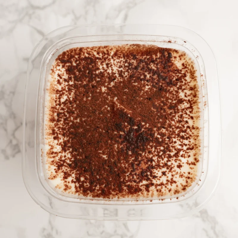 Tiramisu fotograferad ovanifrån med ett jämnt lager kakaopulver på toppen